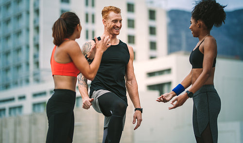 Fitness colleagues standing on rooftop and talking 