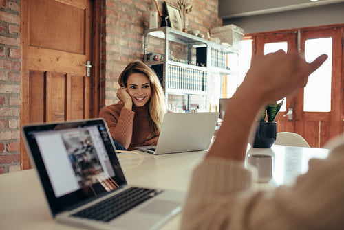 Young woman sitting at table with laptop