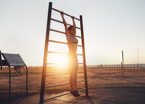 Fitness woman doing stretching workout on wall bars