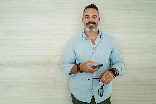 Mature businessman using a smartphone in a modern workplace
