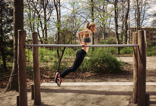 Young woman doing parallel bar dips