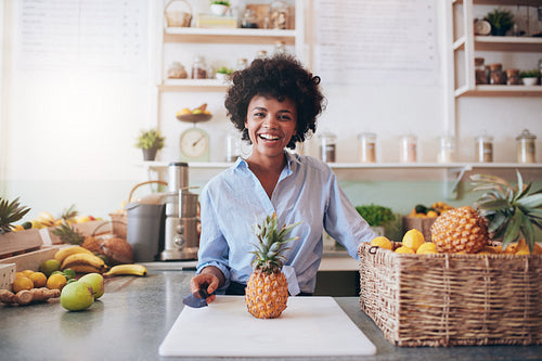 Cheerful young african woman working at juice bar