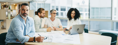 Experienced design professional sitting in a meeting with his te