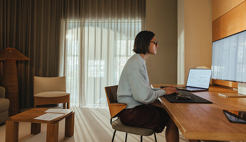 Woman works on a laptop at a desk in a bright office