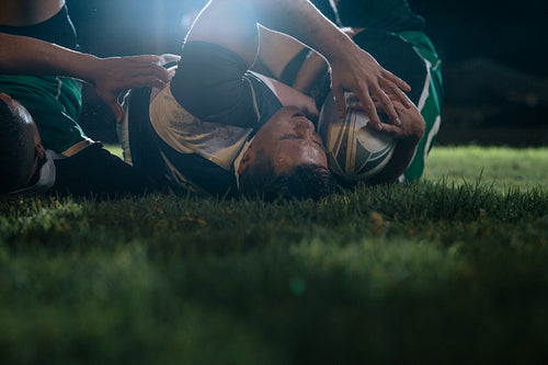Rugby players fighting for ball at stadium