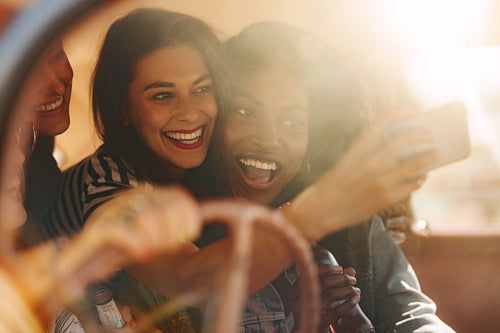 Friends taking selfie in the car