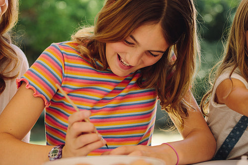 Girl applying paint on easter egg