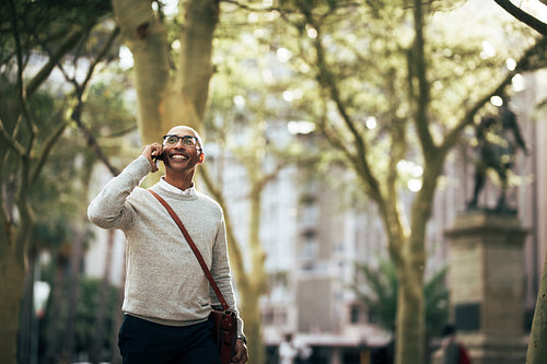 Businessman talking over mobile phone while commuting to office