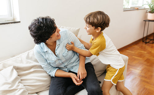 Small boy playing with his mother at home