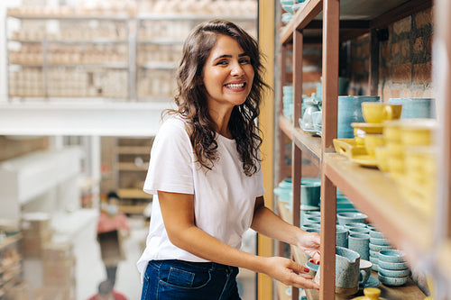 Happy ceramic shop owner smiling at the camera in her store