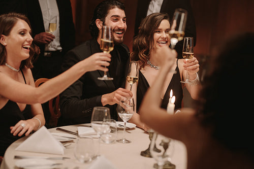 Group of friends toasting champagne at dinner party