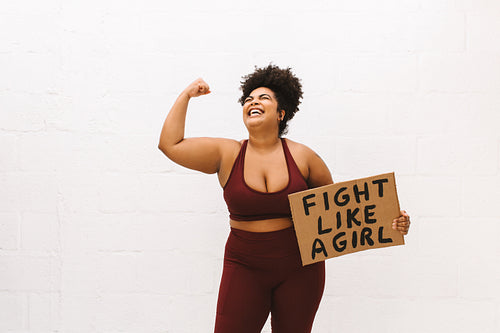 Strong plus size woman with "Fight like a girl" placard