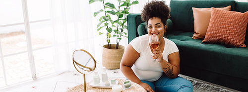 Woman drinking wine during beauty treatment at home