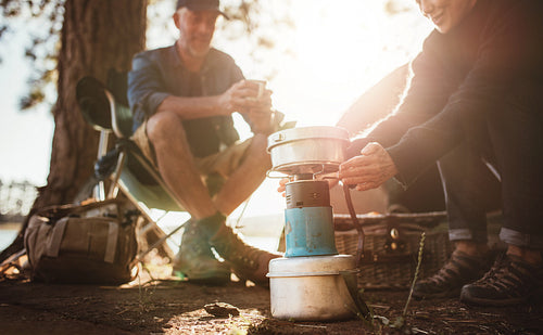 Woman warming hands on stove at campsite