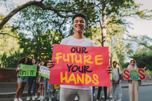 Happy teenage boy protesting during a climate change rally