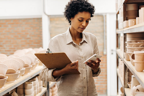 Ceramic store owner reading a text message on her smartphone