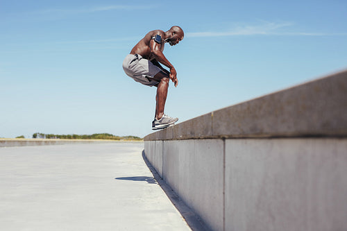 Shirtless young athlete doing jumping workout