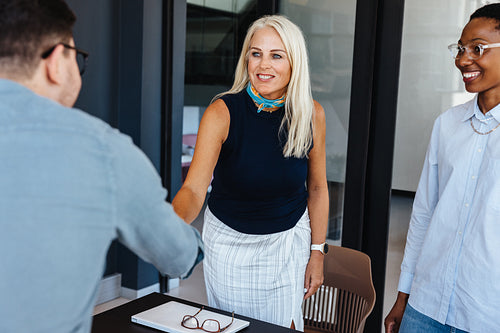 Team members engaging in a professional handshake during a business meeting