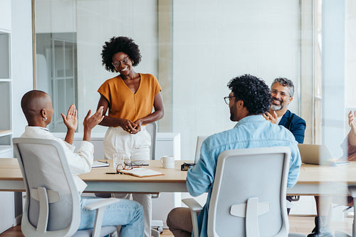 Successful business team applauding and celebrating their project in a creative boardroom meeting