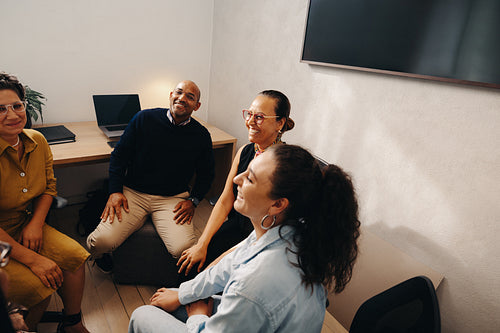 Group of coworkers chatting during a meeting in a modern office setting