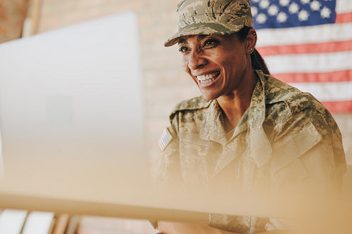 Happy female soldier video chatting with her family on a laptop