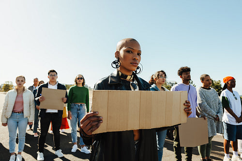 Group of diverse protestors holding blank signs during outdoor demonstration for a cause