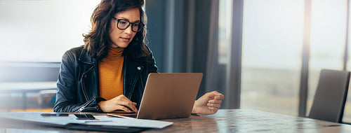 Asian business woman working on a laptop in a professional office