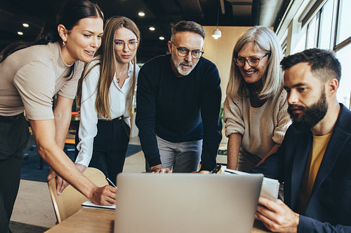 Team of businesspeople using a laptop in an office