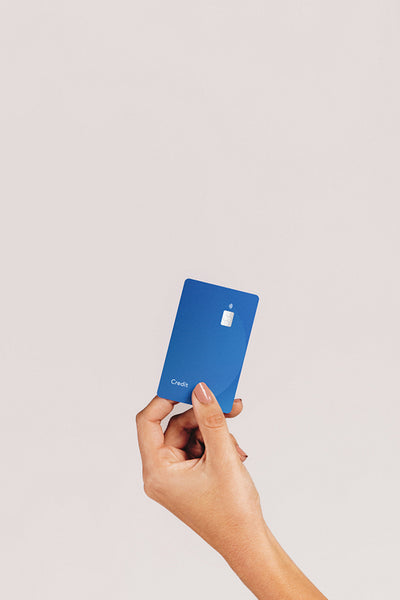 Cashless lifestyle: Female hand holds up a credit card in a studio