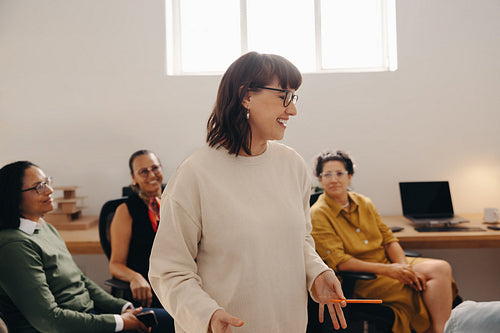 Successful female business owner presenting to team in modern office space