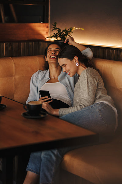 Women laughing and having fun at a coffee shop.