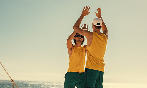 Winning champions: Australian volleyball team celebrating victory on beach at sunset