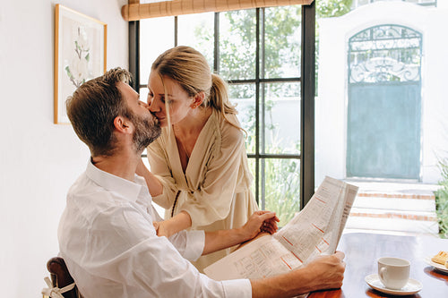 Romantic couple kissing at a tea table in a hotel