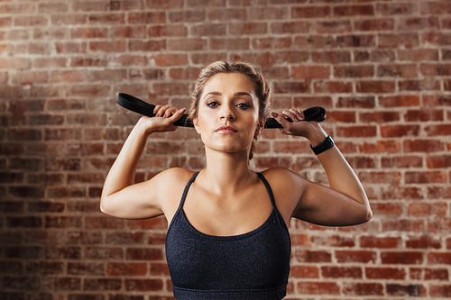 Young woman doing neck exercises using a band.