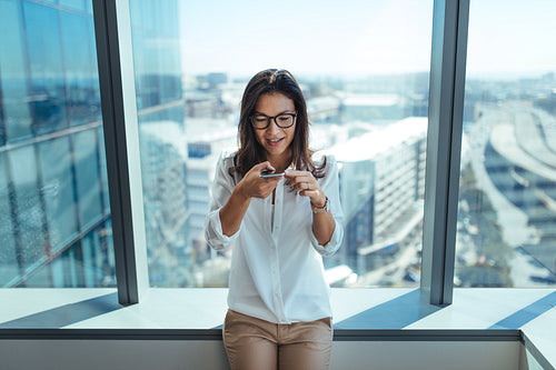 Businesswoman sending voice message using mobile phone.