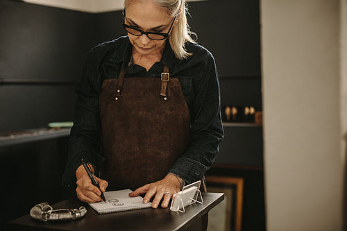 Jewelry designer sketching out designs in studio