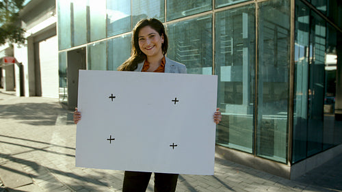 Smiling businesswoman holding empty billboard