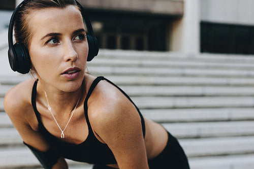 Fitness woman training outdoors listening to music