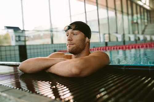 Young man on the edge of swimming pool