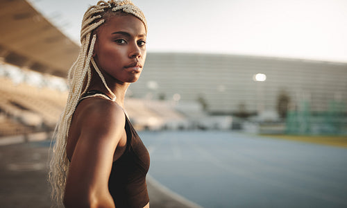 Female athlete standing inside a stadium