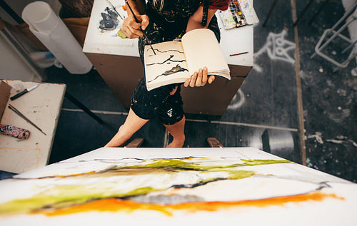 Female painter sitting in studio making a drawing