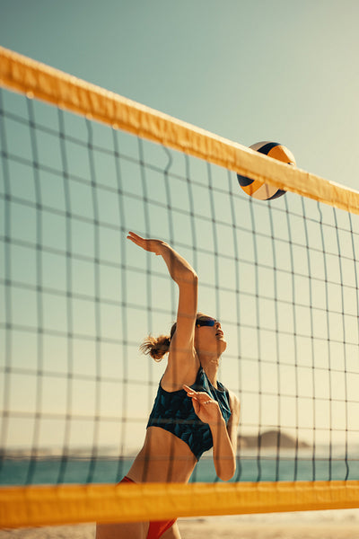 Summer games: Pro tour beach volleyball champion spiking the ball during a coastal match