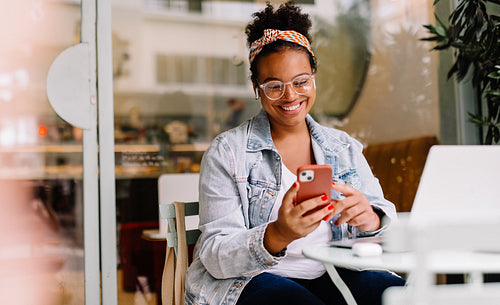 Female freelancer using smartphone in a cafe