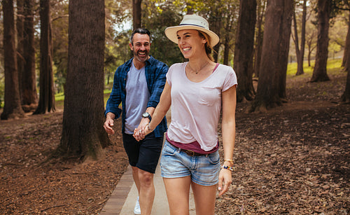 Beautiful couple walking through park and smiling