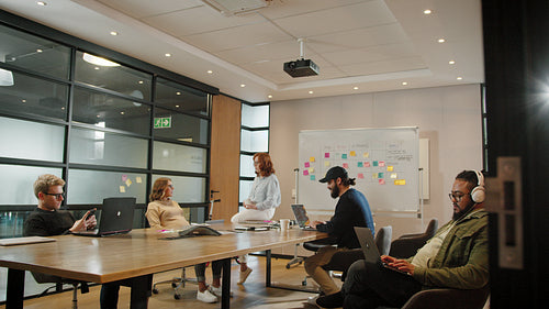 Software developers sitting and working in a boardroom