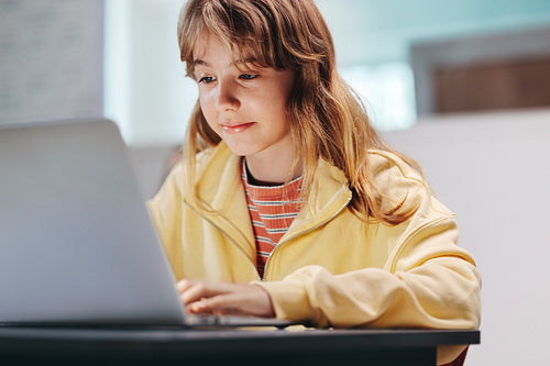 Fostering innovation: Child sitting with a laptop in a coding classroom