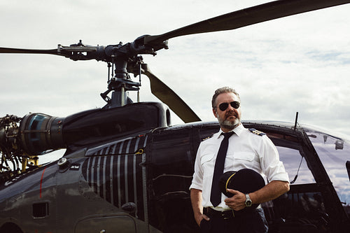 Helicopter pilot in sunglasses by helicopter