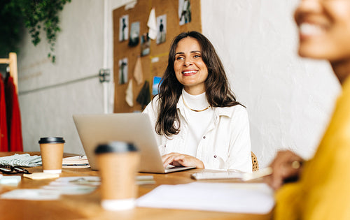 Fashion design team having a meeting with a client in a small business office