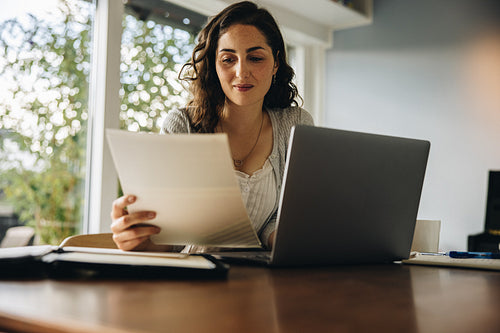 Woman reading some documents at home office
