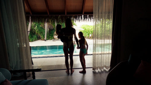 Mother and children running and jumping into their private resort pool